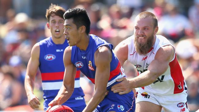 Lin Jong is tackled by Max Gawn. (Photo by Quinn Rooney/Getty Images)