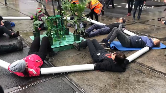 Climate protesters link arms together with pipes in Melbourne CBD