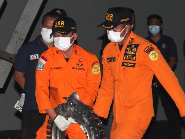 Rescue personnel carry a piece of wreckage recovered from the crash site of Sriwijaya Air flight SJ182 in 2021. Picture: AFP