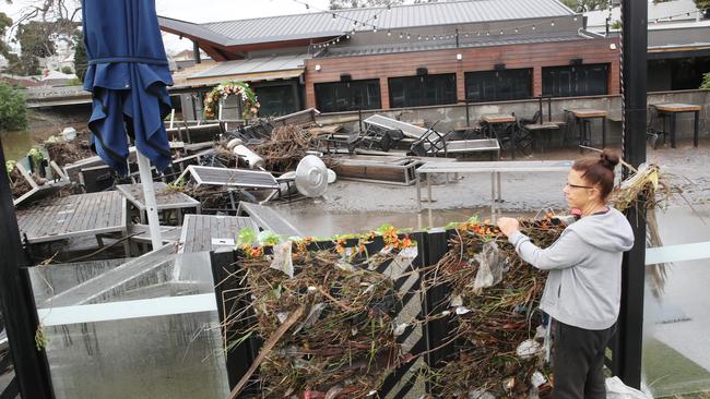 A resident inspects the beer garden of the Anglers Tavern in Maribyrnong after the floods. Picture: David Crosling