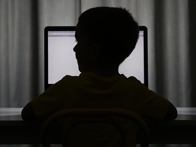 A silhouette of a young child looking at a computer monitor. Pictures: Jack Tran