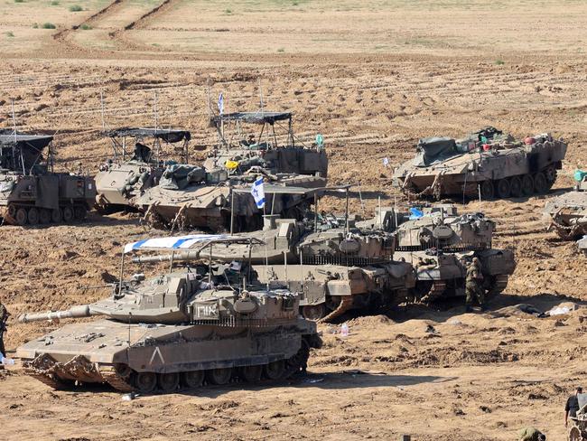 Israeli troops gather with their military vehicles on the border with the Gaza Strip on November 30, 2023, on the 7th day of a truce in battles between Israel and Hamas militants. Israel and Hamas have agreed to extend by one more day a truce under which hostages are exchanged for Palestinian prisoners and aid flows into the war-devastated Gaza Strip. (Photo by GIL COHEN-MAGEN / AFP)