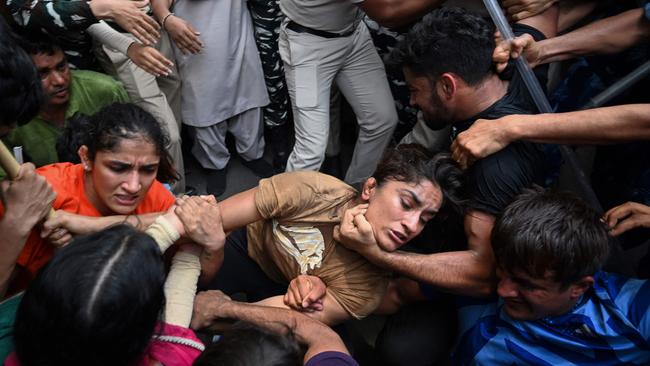 Vinesh Phogat (centre) is detained by the police while attempting to march to India's new parliament last year. (Photo by Arun THAKUR / AFP)