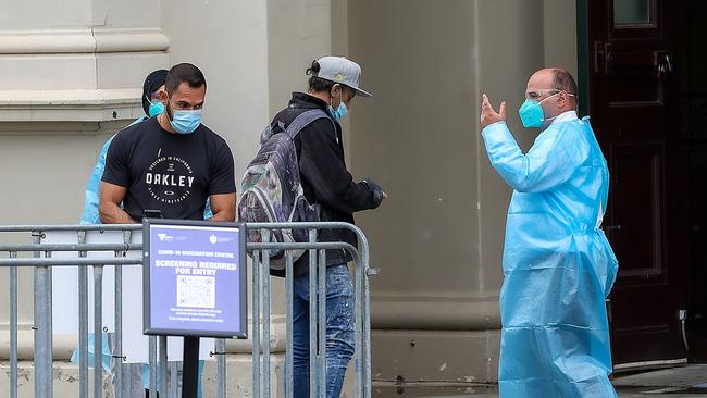 People head into the Royal Exhibition Building to get a Covid-19 vaccination. Picture: Ian Currie