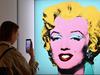 (FILES) In this file photo taken on April 29, 2022 a woman takes a photo of Andy Warhol's 'Shot Sage Blue Marilyn' during Christie's 20th and 21st Century Art press preview at Christie's New York in New York City. - An iconic portrait of Marilyn Monroe by American pop art visionary Andy Warhol went under the hammer for a record $195 million on May 9, 2022 at Christie's, becoming the most expensive 20th century artwork ever sold at public auction. "Shot Sage Blue Marilyn," produced in 1964 two years after the death of the glamourous Hollywood star, sold for exactly $195.04 million, including fees, in just four minutes in a crowded room at Christie's headquarters in Manhattan. (Photo by Angela Weiss / AFP)