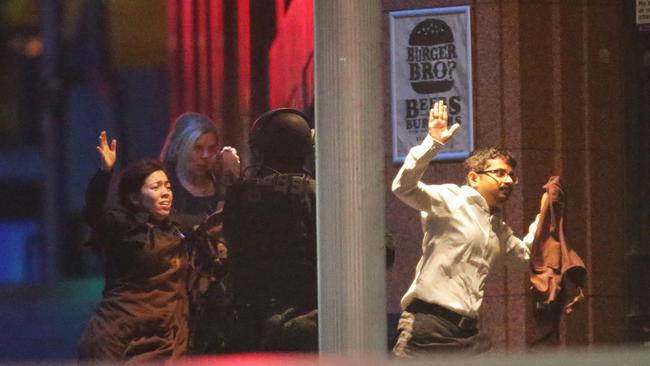 Hostages flee from the Lindt Cafe as the 16-hour siege ended in 2014. Picture: Bill Hearne