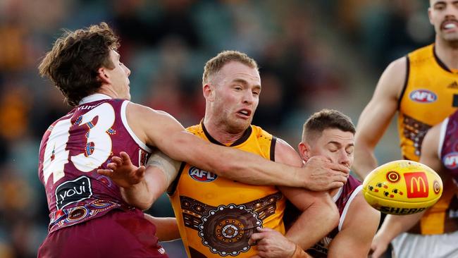 Noah Answerth (left) and Dayne Zorlko surround Hawthorn’s Tom Mitchell. Picture: Dylan Burns/AFL Photos via Getty Images