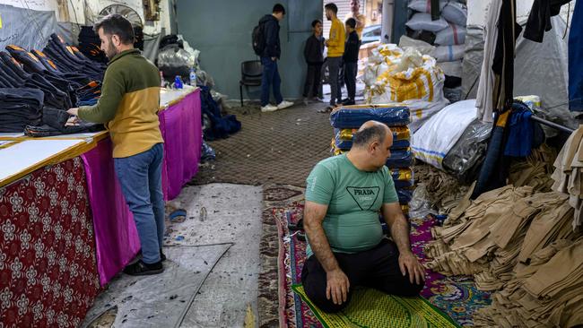 A man prays as Syrian refugees work in a Syrian owned clothing factory in Gaziantep, on December 10, 2024. Islamist-led rebels declared on December 8, 2024, that they have taken the Syrian capital in a lightning offensive, sending President Bashar al-Assad fleeing and ending five decades of Baath rule in Syria. (Photo by Yasin AKGUL / AFP)