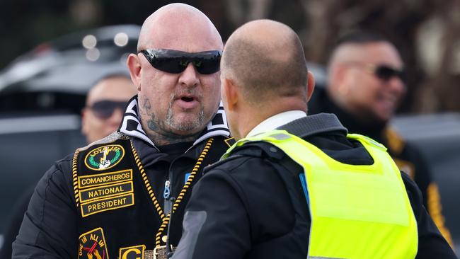 Former Comanchero president Mick Murray talks with police after having his identification checked at the United Petrol Station in Tooradin. Picture: Ian Currie