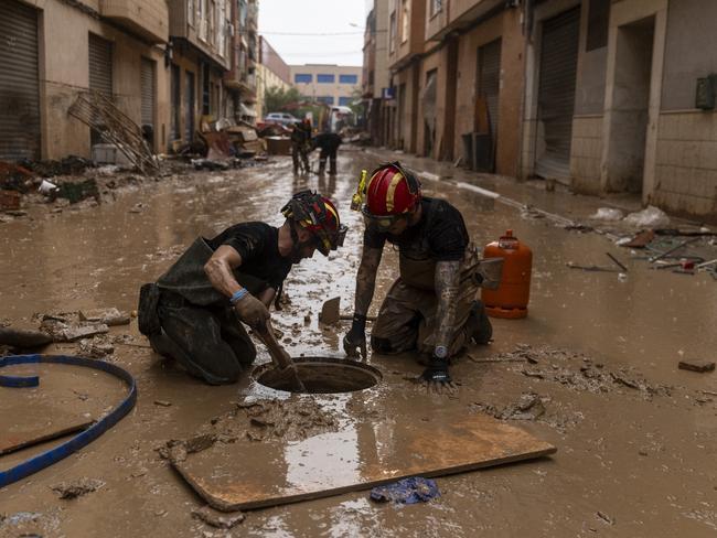 Members of the Military Emergency Unit (UME) clear a sewer during a rainfall after heavy rain and flooding n the Alfafar municipality, in Valencia, Spain. Picture: Getty Images