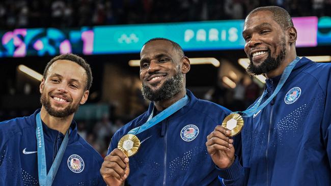 TOPSHOT - Gold medallists (From L) USA's #04 Stephen Curry, USA's #06 LeBron James and USA's #07 Kevin Durant pose after the men's Gold Medal basketball match between France and USA during the Paris 2024 Olympic Games at the Bercy  Arena in Paris on August 10, 2024. (Photo by Damien MEYER / AFP)