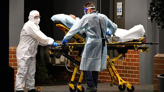 Healthcare workers transport a person into a patient transport vehicle at the Arcare Maidstone nursing home in Melbourne’s west on Wednesday. Picture: AAP