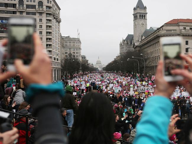 People take photos as protesters walk during the Women's March on Washington. Picture: Mario Tama/Getty Images