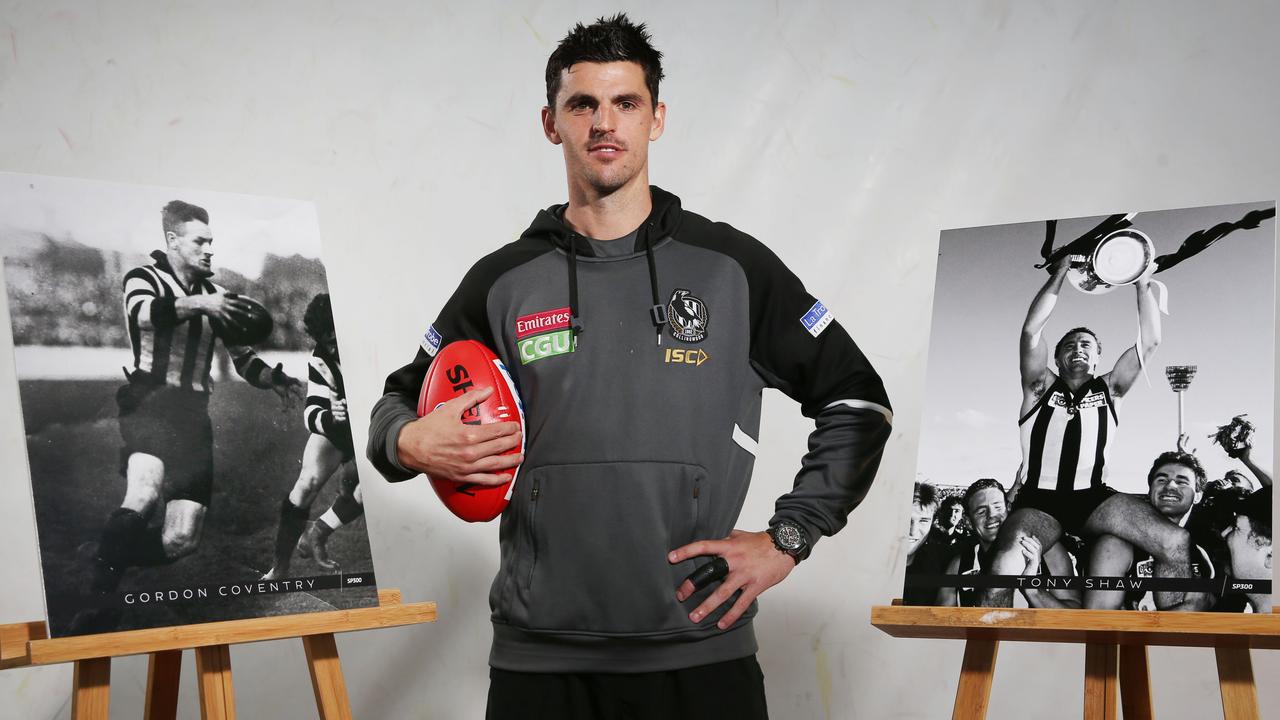 Scott Pendlebury between portraits of Collingwood 300 gamers Gordon Coventry and Tony Shaw. Picture: AAP