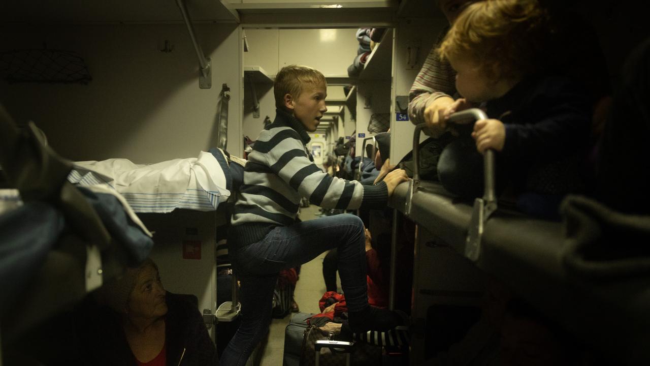 A boy climbs into a bunk bed after boarding an evacuation train. Picture: Getty Images.