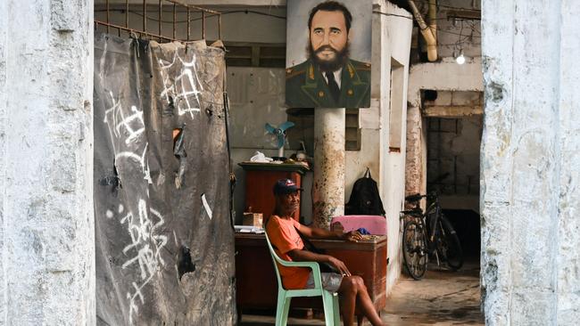 A man sits next to a poster of late Cuban leader Fidel Castro in Havana. Picture: AFP