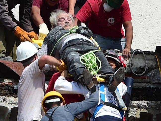 A man is pulled out of the rubble alive following a quake in Mexico City on September 19, 2017. A powerful earthquake shook Mexico City on Tuesday, causing panic among the megalopolis' 20 million inhabitants on the 32nd anniversary of a devastating 1985 quake. The US Geological Survey put the quake's magnitude at 7.1 while Mexico's Seismological Institute said it measured 6.8 on its scale. The institute said the quake's epicenter was seven kilometers west of Chiautla de Tapia, in the neighboring state of Puebla.  / AFP PHOTO / Ronaldo SCHEMIDT