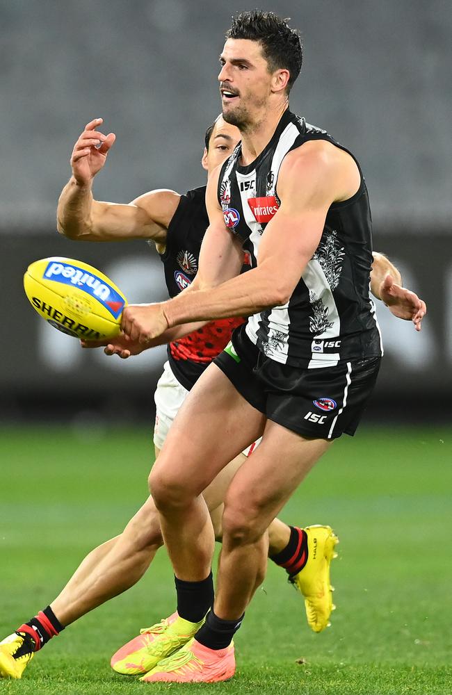 Scott Pendlebury handballs under pressure from Dylan Shiel. Picture: Quinn Rooney/Getty Images