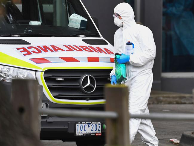 An ambulance is seen outside one of nine public housing estates locked down due to a spike in COVID-19 coronavirus numbers in Melbourne on July 6, 2020. - Australia will effectively seal off the state of Victoria from the rest of the country, authorities said on July 6, announcing unprecedented measures to tackle a worrying surge in coronavirus cases. (Photo by William WEST / AFP)