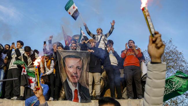 People in Istanbul hold a banner featuring Turkish President Recep Tayyip Erdogan as members of the Syrian community celebrate the fall of Bashar al-Assad. Picture: AFP