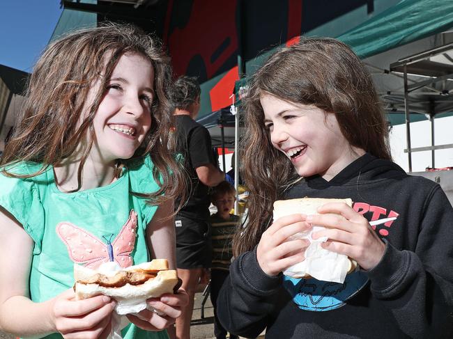 Zali and Isla Schipper enjoy the chance to tuck into a Bunnings Sausage Sizzle, back after being restricted due to COVID-19. Picture: Tim Hunter.