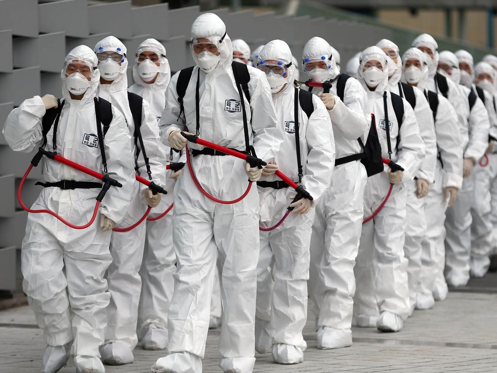 South Korean soldiers wearing protective gear move to spray disinfectant as part of preventive measures against the spread of coronavirus. Picture: YONHAP/AFP