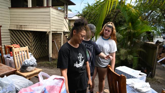 Jo Taufa, left, and her children salvage items from their flood-affected home in Lismore. Picture: Getty Images