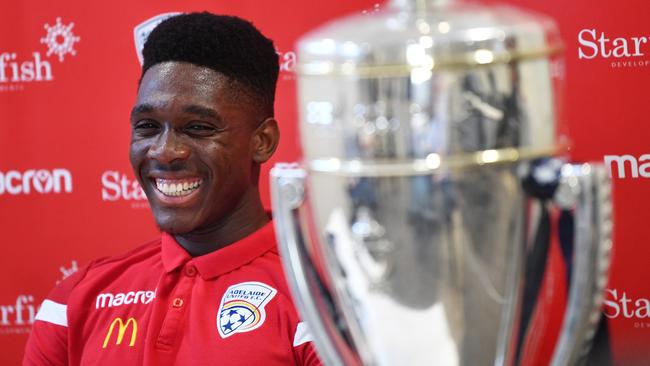 Adelaide United’s Al Hassan Toure with the FFA Cup trophy at the club’s training centre on Thursday. Picture: AAP