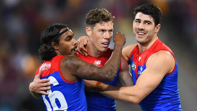 BRISBANE, AUSTRALIA - AUGUST 19: Christian Petracca of the Demons celebrates with Kysaiah Pickett and Jake Melksham after kicking a goal during the round 23 AFL match between the Brisbane Lions and the Melbourne Demons at The Gabba on August 19, 2022 in Brisbane, Australia. (Photo by Albert Perez/AFL Photos via Getty Images)