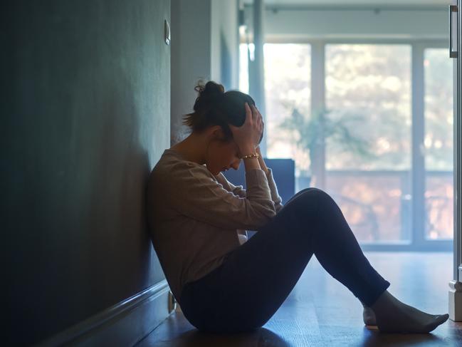 istock generic:  woman, abuse, DV, domestic violence, harassment, sexual harassment.   Sad Young Woman Sitting on the Floor In the Hallway of Her Appartment, Covering Face with Hands. Atmosphere of Depression, Trouble in Relationship, Death in the Family. Dramatic Bad News Moment . Picture: istock