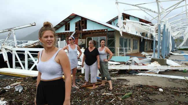 Airlie Beach residents Maika McDonald,15, Lauren Squires, Karen Gordon, and Katelin Gordon, survey the damage at Shute Harbour Terminal after cyclone Debbie.