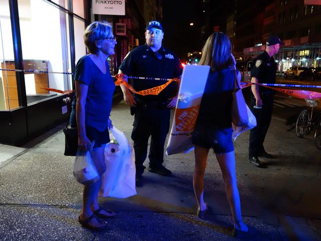 Two woman look on as police block a road after an explosion in New York's Chelsea neighbourhood. Picture: AFP / William Edwards