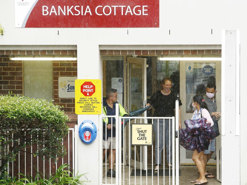 Masked Parents arrive to pick their child up from Banksia Cottage Childcare within the Macquarie University Campus. Picture: John Appleyard