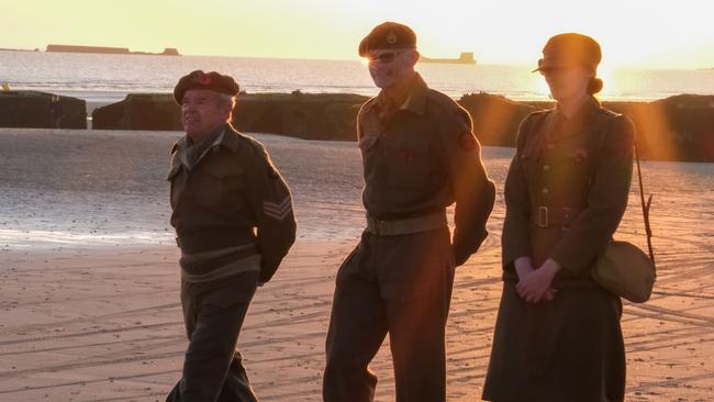 Military personnel walk on Arromanches-les-bains in Normandy as dawn breaks on the 80th anniversary of D-Day. Picture: Jacquelin Magnay