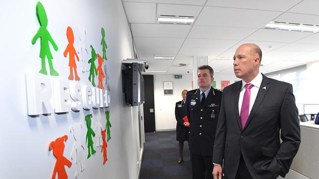 Federal Minister for Home Affairs Peter Dutton (right) and Federal Police Commissioner Andrew Colvin look on to 'Rescued' signage while touring the Australian Centre to Counter Child Exploitation (ACCCE) in Brisbane, Monday, September 3, 2018. (AAP Image/Dave Hunt) NO ARCHIVING