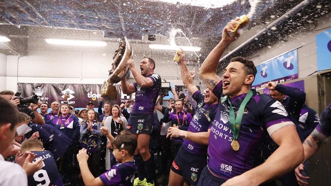 Melbourne's Cameron Smith, Cooper Cronk and Billy Slater sing the team song in the victorious dressing room.