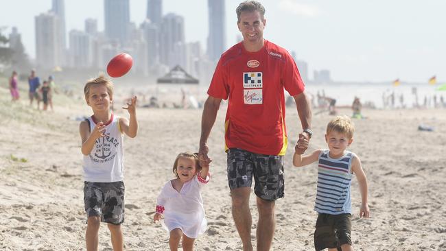 Marcus Ashcroft with Will, 6, Levi, 4, and Lucy, 1 at Mermaid Beach.