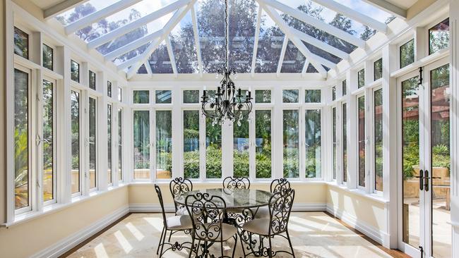 A glass-encased conservatory is among the home’s many living spaces.