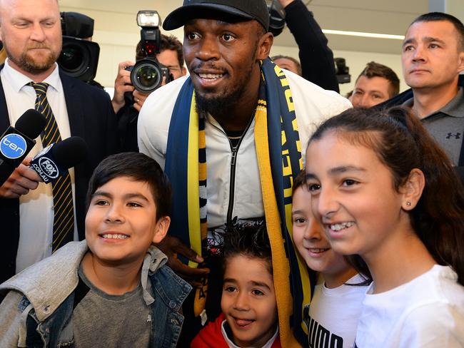 Usain Bolt poses for pictures with young fans at Sydney Airport on Saturday. Picture: AFP