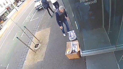 A man removes the box of free masks from Elgin St in Carlton.