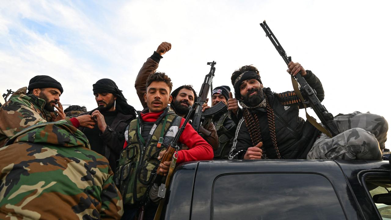 Anti-government fighters celebrate at Umayyad Square in Damascus. Picture: Louai Beshara/AFP