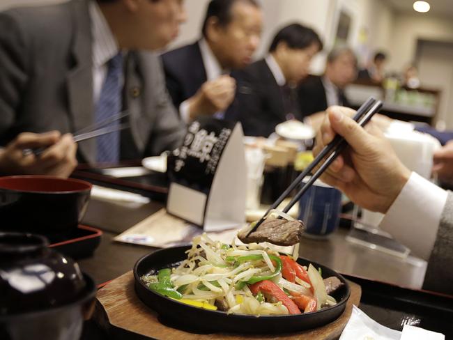 Lack of interest ... Japanese lawmakers and government officials try whale meat dishes to promote whale meat, which is now rarely eaten in the country. Picture: AP