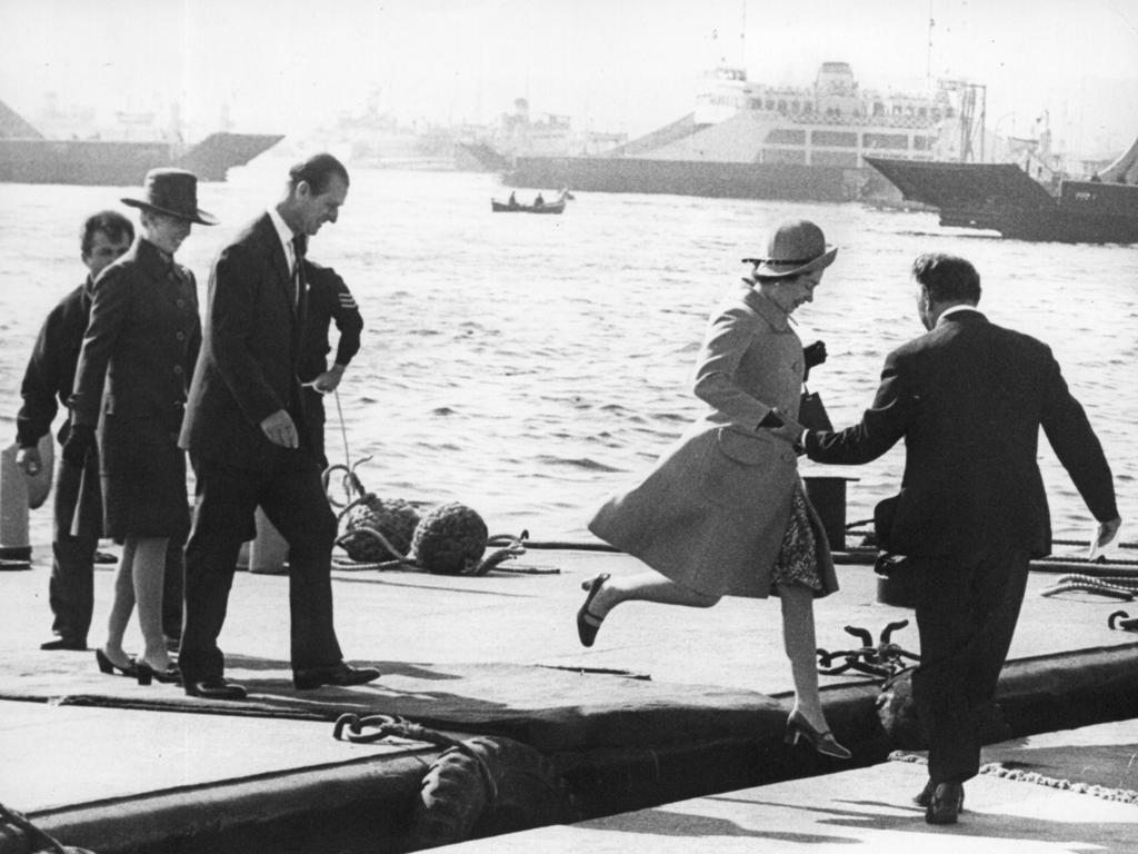 Queen Elizabeth II being helped ashore following by Prince Phillip during their Royal Visit to Australia in 1970.