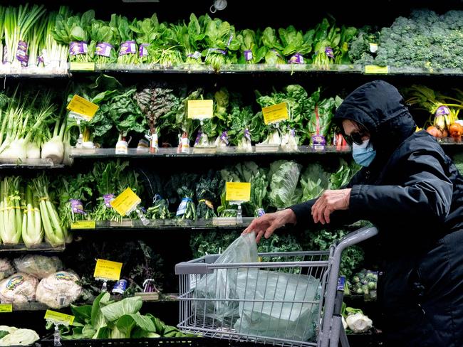 A shopper wears a protective mask at a grocery store in Washington, DC, on February 19, 2022. - Mayor Muriel Bowser announced the US capital was dialing back its indoor mask requirement on March 1. Masks will not be required at restaurants and bars, sports and entertainment venues, gyms, recreation centers, indoor athletic facilities, houses of worship, businesses, grocery stores and pharmacies, retail establishments and DC government offices that don't have direct contact with the public. (Photo by Stefani Reynolds / AFP)