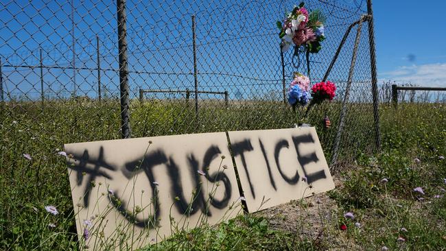 A sign calling for justice appeared at the crash site where Ned and Nan Walker and their daughter Sue Skeer lost their lives in a head-on collision on the day the 16-year-old driver made his first court appearance. Picture: Jessica Ball