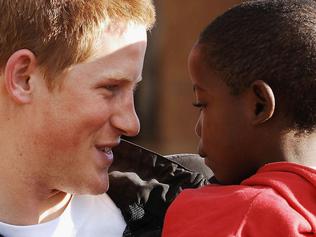 LESOTHO - APRIL 24: (EMBARGOED: NOT FOR PUBLICATION BEFORE 0001 FRIDAY APRIL 28, 2006.) Prince Harry holds his old friend, Mutsu Potsane, in the grounds of the Mants'ase children's home, while on a return visit to Lesotho on April 24, 2006 in southern Africa. The Prince was in the country to launch his new charity called 'Sentebale', which means 'Forget me not' in memory of his mother Princess Diana. (Photo by Pool/Anwar Hussein Collection/Getty Images)