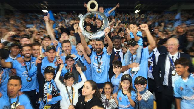 Alex Brosque raises the Trophy infront of the Cove after Sydney won the grand final against Melbourne Victory at Allianz Stadium. Picture: Mark Evans