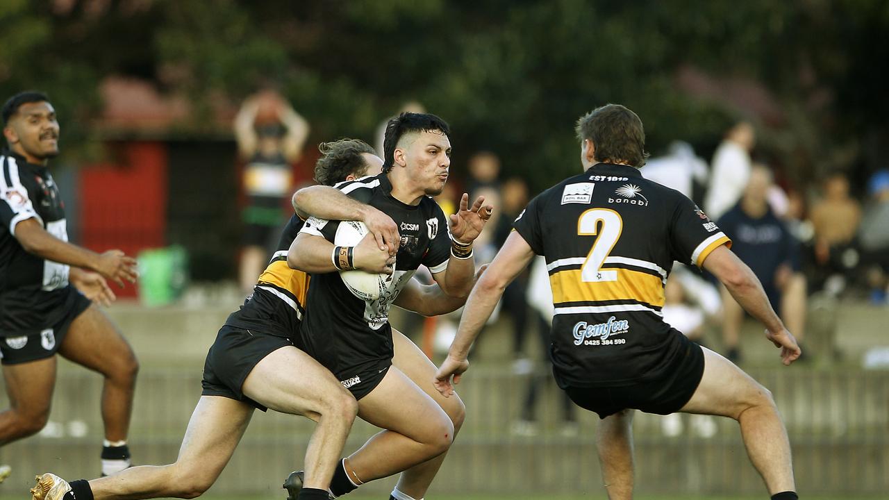 Redfern's James Frazer is tackled by Joshua Natoli. Picture: John Appleyard