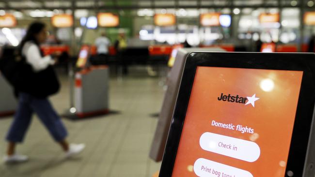 A woman walks past an empty Jetstar self check-in console at Sydney Domestic Airport. Picture: Getty Images