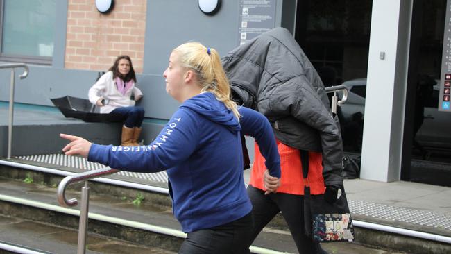 Stephanie Belthikiotis covers her face as she leaves Wyong Local Court on Tuesday morning following her arrest on May 22.